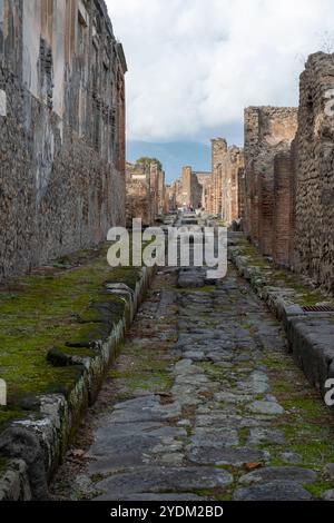 Strada lastricata di pietra che mostra solchi di carri e carri, Parco Archeologico di Pompei, Napoli, Italia. Foto Stock