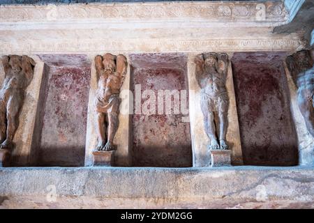 Statue in miniatura decorano le pareti all'interno di una casa termale di Pompei, parco archeologico di Pompei, Napoli Italia. Foto Stock