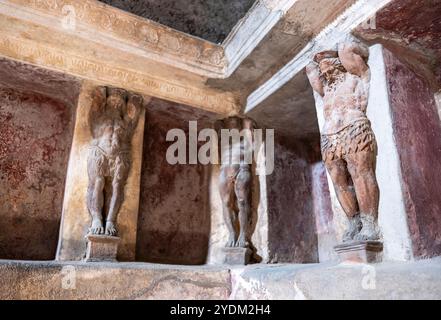 Statue in miniatura decorano le pareti all'interno di una casa termale di Pompei, parco archeologico di Pompei, Napoli Italia. Foto Stock