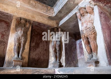 Statue in miniatura decorano le pareti all'interno di una casa termale di Pompei, parco archeologico di Pompei, Napoli Italia. Foto Stock