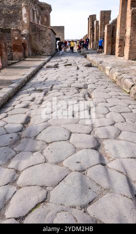 Strada lastricata di pietra che mostra solchi di carri e carri, Parco Archeologico di Pompei, Napoli, Italia. Foto Stock