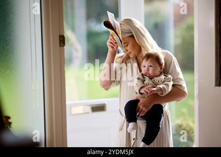 La mamma e il bambino raccolgono il palo dalla porta d'ingresso Foto Stock