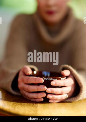 Donna che mantiene tazza da caffè Foto Stock