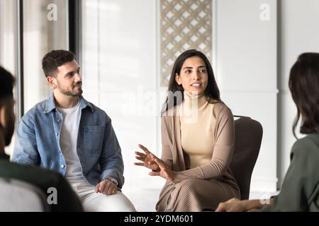 Medico latino di terapia di gruppo che parla con diversi pazienti Foto Stock