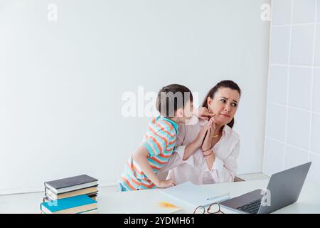 Insegnante che insegna Boy su notebook a School Online Foto Stock