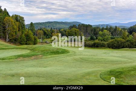 Un campo da golf verde tra le colline ondulate con un cielo nuvoloso in una splendida giornata estiva in Canada Foto Stock