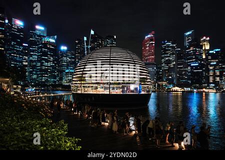 Singapore - 14 agosto 2024: Vista notturna delle Apple Marina Bay Sands con sfondo grattacielo. Foto Stock