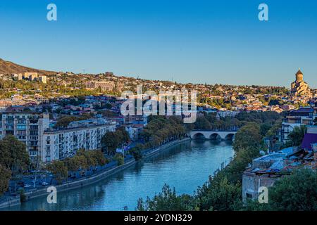 Tbilisi, Georgia. 27 ottobre 2024. La luce soffusa del tardo pomeriggio cade su Tbilisi, creando un'atmosfera tranquilla nella capitale georgiana. Visto dall'altra parte del fiume domenica 27 ottobre 2024, un giorno dopo le elezioni, il paesaggio urbano rivela una miscela di architettura tradizionale e moderna. L'iconica cattedrale di Sameba si erge sopra i tetti, con la sua cupola dorata che risplende come simbolo di fede e patrimonio culturale nell'evoluzione dello skyline di Tbilisi. (VX Photo/ Vudi Xhymshiti) crediti: VX Pictures/Alamy Live News Foto Stock