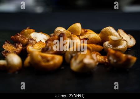 Funghi dorati fritti su sfondo nero. Messa a fuoco selezionata. Foto di alta qualità Foto Stock