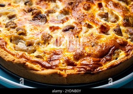 Quiche Laurent secondo una ricetta tradizionale francese. Torta con pollo e funghi su un piatto blu. Primo piano. Foto di alta qualità Foto Stock