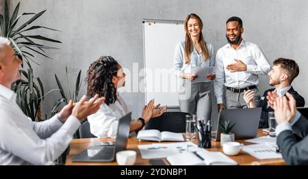 Colleghi applaudi applaudendo i colleghi dopo aver parlato con successo in Office Foto Stock