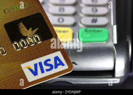 Logo VISA sulla carta di credito con terminale di pagamento sullo sfondo Foto Stock