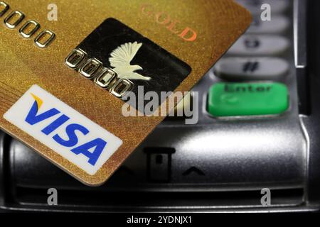 Logo VISA sulla carta di credito con terminale di pagamento sullo sfondo Foto Stock