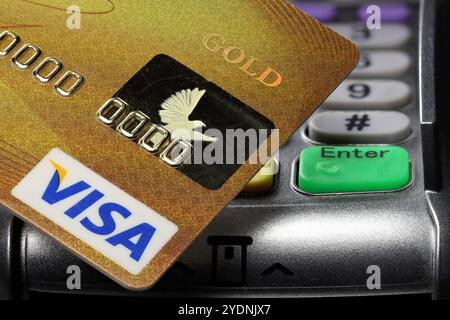Logo VISA sulla carta di credito con terminale di pagamento sullo sfondo Foto Stock