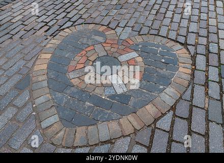 Il mosaico incastonato nei ciottoli della Royal Mile a Edimburgo raffigura il famoso Cuore di Midlothian. Foto Stock