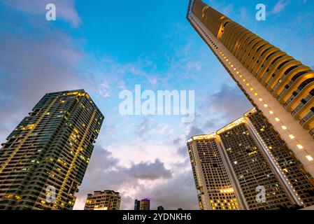 Lungo il fiume principale, attraversa uno dei quartieri centrali più esclusivi di Manila, i condomini e gli uffici si illuminano, illuminati in modo luminoso Foto Stock