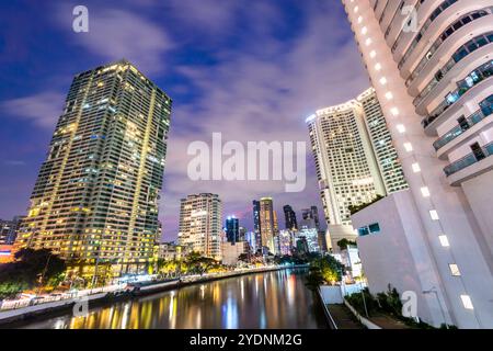 Lungo il fiume principale, attraversa uno dei quartieri centrali più esclusivi di Manila, i condomini e gli uffici si illuminano, illuminati in modo luminoso Foto Stock