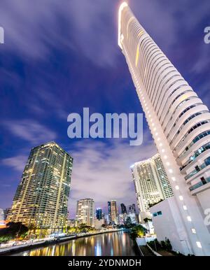 Lungo il fiume principale, attraversa uno dei quartieri centrali più esclusivi di Manila, i condomini e gli uffici si illuminano, illuminati in modo luminoso Foto Stock