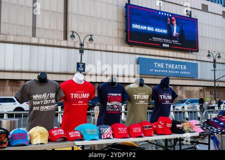 New York, New York, Stati Uniti. 27 ottobre 2024. Folle di sostenitori di Donald Trump, molti con berretti e camicie marchiati MAGA o Trump, si riuniscono fuori dal Madison Square Garden prima di un raduno serale. Una mostra di cappellini e T-shirt Trump sulla 8th Avenue di fronte al Madison Square Garden. Crediti: Ed Lefkowicz/Alamy Live News Foto Stock