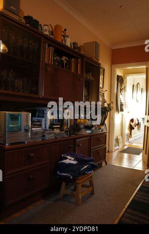 impianto stereo e libri su un armadio da sala da pranzo degli anni '1980 con luce naturale Foto Stock