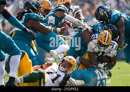 Jacksonville, Florida, Stati Uniti. 27 ottobre 2024. National Football League, Jacksonville Jaguars vs Green Bay Packers. Il running back dei Green Bay Packers Emanuel Wilson (31) è stato un gang tackle dal defensive tackle dei Jacksonville Jaguars Jeremiah Ledbetter (99), dal linebacker Foyesade Oluokun (23) e dal defensive end Josh Hines-Allen (41). Foto: Tim Davis/Alamy Live News Foto Stock