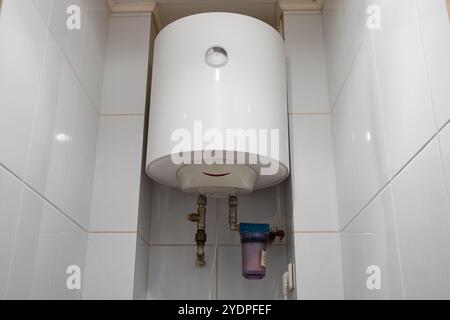 Lo scaldabagno bianco è appeso nella toilette in appartamento in Ucraina Foto Stock