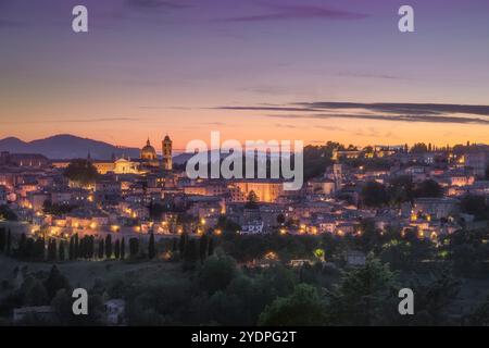 Skyline di Urbino dopo il tramonto. Sito patrimonio dell'umanità dell'UNESCO. Regione Marche, Italia, Europa. Foto Stock