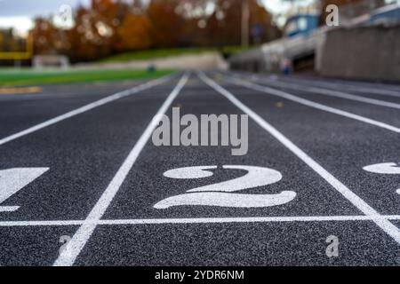 Avvicinati alla corsia numero 2 su una nuova pista da corsa nera con linee bianche e altre linee di demarcazione. Foto Stock