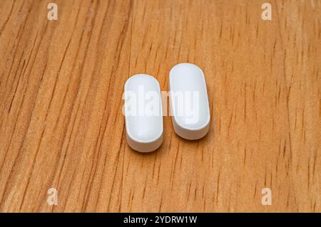 Immagine macro di compresse generiche di acetaminofene (paracetamolo), senza segni, su un tavolo di legno. Foto Stock