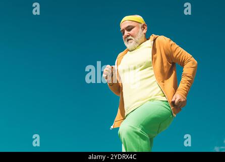 Uomo anziano che corre nella natura soleggiata. Il miglior allenamento cardiovascolare. Senior fitness persona che corre nel parco per una buona salute. Salute stile di vita allegro. Anziani Foto Stock