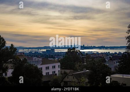 Vista sul crepuscolo della collina che guarda attraverso la città di Berkeley al Bay Bridge e a San Francisco. Foto Stock