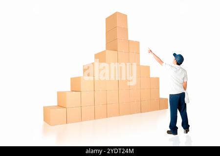 Lavoratore che indica una pila di scatole di cartone Foto Stock