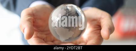 L'uomo d'affari fortunato tiene il globo di vetro con i continenti nelle mani Foto Stock