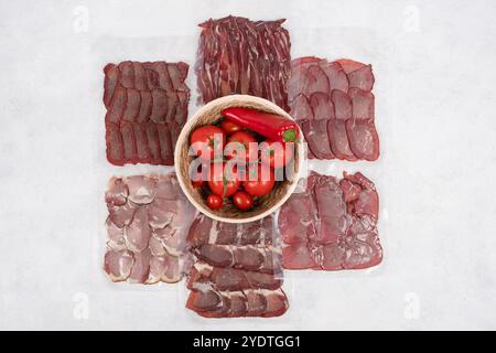 Affettati assortiti con pomodori freschi e peperoni - Selezione di salumi gourmet per gli appassionati di cucina e Fotografia gastronomica Foto Stock