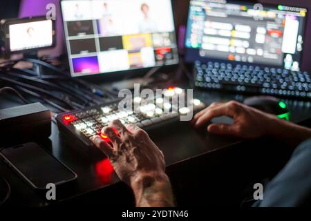 Mani di esperti TV Director maschio maturo pannello di controllo operativo in Studio durante la produzione in live streaming Foto Stock