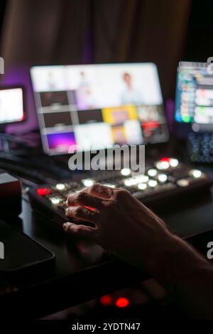 Mani di esperti TV Director maschio maturo pannello di controllo operativo in Studio durante la produzione in live streaming Foto Stock