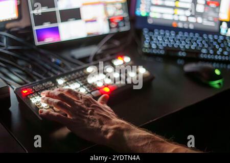 Mani di esperti TV Director maschio maturo pannello di controllo operativo in Studio durante la produzione in live streaming Foto Stock