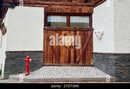 Porta in legno decorata con un cuore, da un'enoteca in Val di Sole Foto Stock