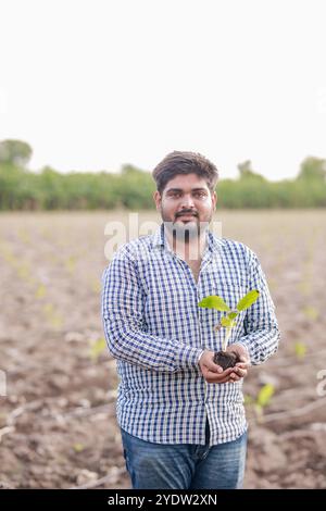 Giovane agricoltore indiano che tiene un albero di banana bambino, cultura tissutale, giovane agricoltore intelligente Foto Stock