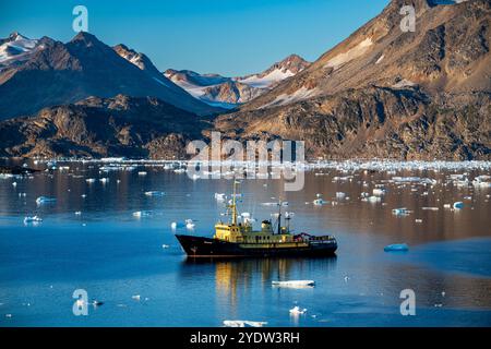 Peschereccio da traino nel fiordo montano, Kulusuk, Groenlandia, Danimarca, regioni polari Foto Stock