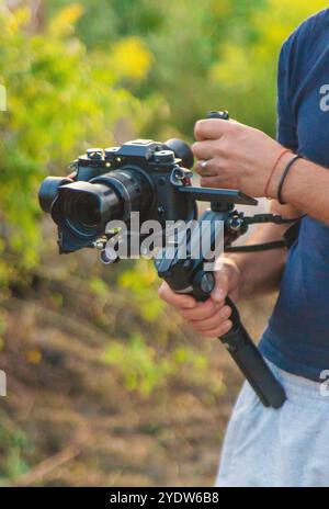 L'operatore registra un video su una videocamera. Messa a fuoco selettiva. Natura. Foto Stock