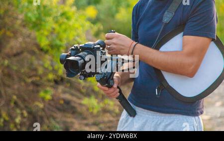 L'operatore registra un video su una videocamera. Messa a fuoco selettiva. Natura. Foto Stock