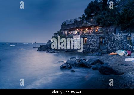 Vista del ristorante costiero vicino al Castello Aragonese al crepuscolo, porto di Ischia, isola di Ischia, Campania, Italia, Europa Foto Stock