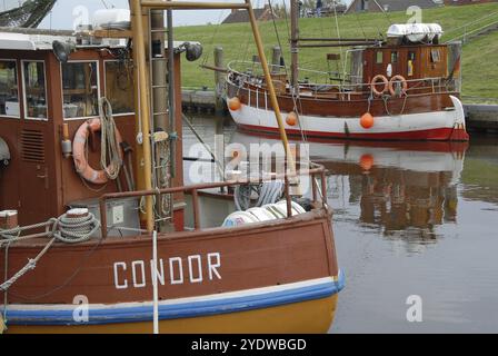 Due barche da pesca nel porto, una con un salvagente, acque calme in primo piano, greetsiel, frisia orientale, germania Foto Stock