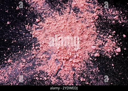 Sfondo di colore rosa della polvere di gesso. Particelle di polvere di colore rosa spruzzate su sfondo nero Foto Stock