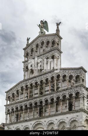 San Michele in foro è una basilica cattolica di Lucca, in Italia. Dettaglio della facciata con una scultura dell'Arcangelo Foto Stock