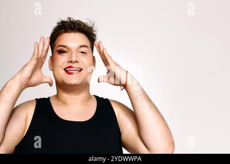 Una persona gioiosa mette in mostra un trucco audace e esprime una creatività unica in modo giocoso. Foto Stock