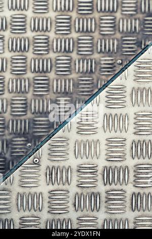 Sfondo astratto, struttura della scala per edifici industriali in piastre metalliche in acciaio inox antiscivolo, messa a fuoco selettiva Foto Stock