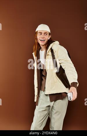 Un ragazzo adolescente dai capelli rossi che colpisce mette in mostra il suo senso della moda in un elegante ambiente da studio. Foto Stock