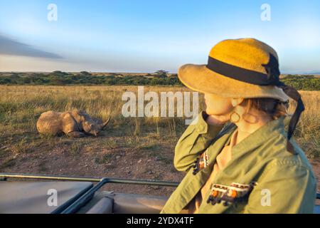 Vacanza Safari. Donna bionda che guarda gli elefanti africani dal tetto di un'auto da safari. Famiglia in vacanza safari nel parco nazionale di Amboseli. Foto della fauna selvatica Foto Stock